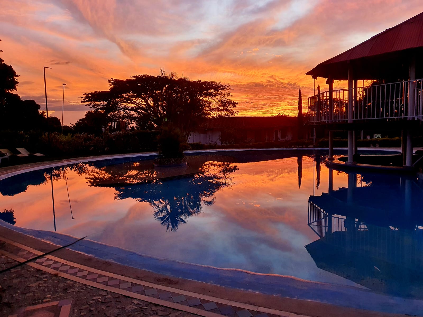 Piscina con atardecer naranja espectacular
