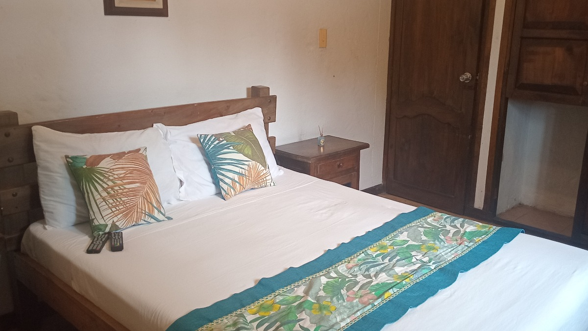 Suite Sencilla - cama con textiles tropicales